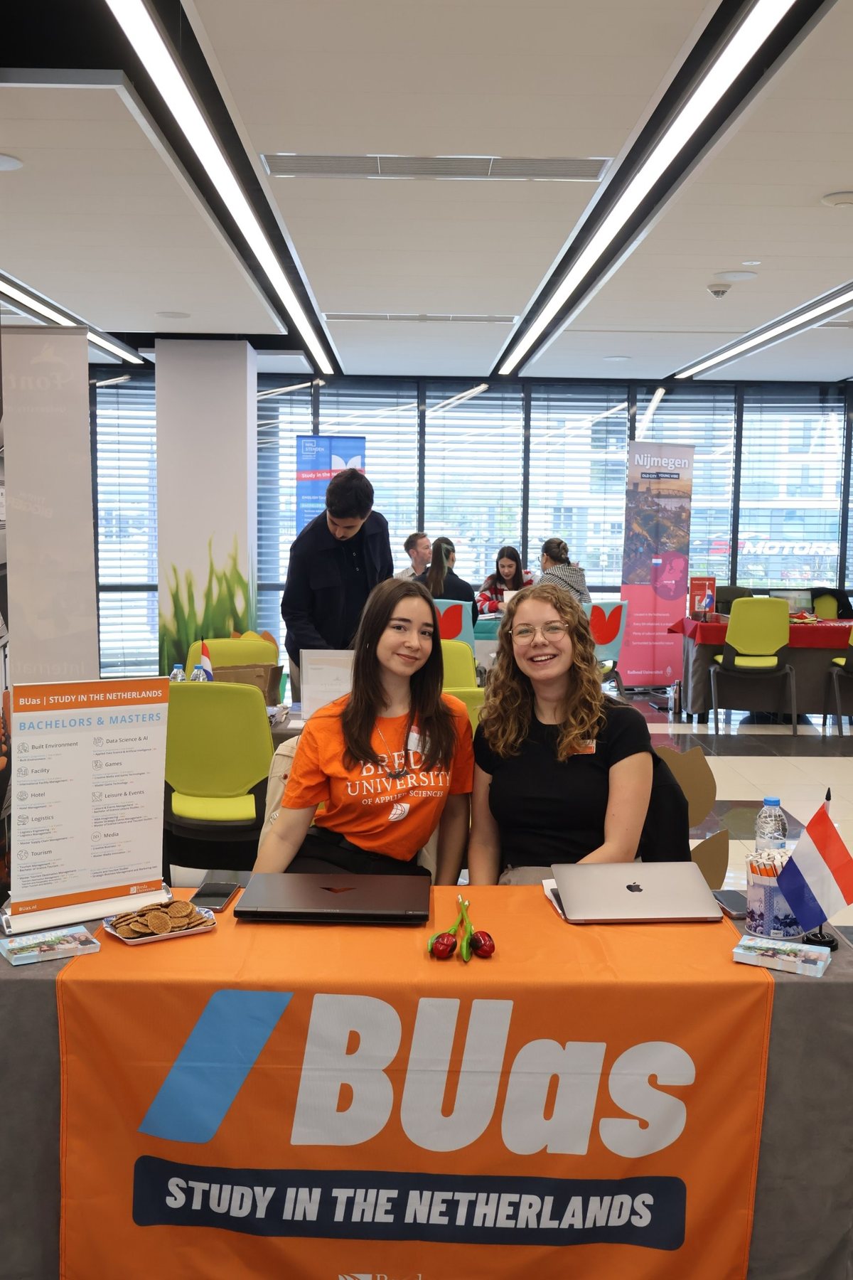 Two BUas representatives smiling behind the BUas stand