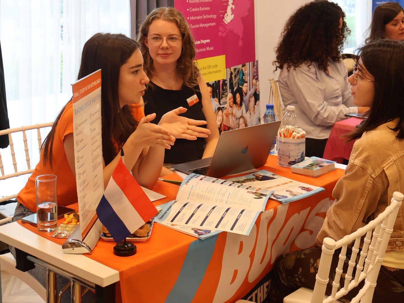 Two BUas representatives at the stand, one explaining something with her hands while the other listens